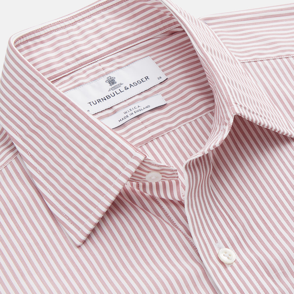 The Turnbull & Asser Burgundy Stripe West Indian Sea Island Cotton Regular Fit Mayfair Shirt features thin vertical red and white stripes, a classic collar, and long sleeves, shown on a plain white background.