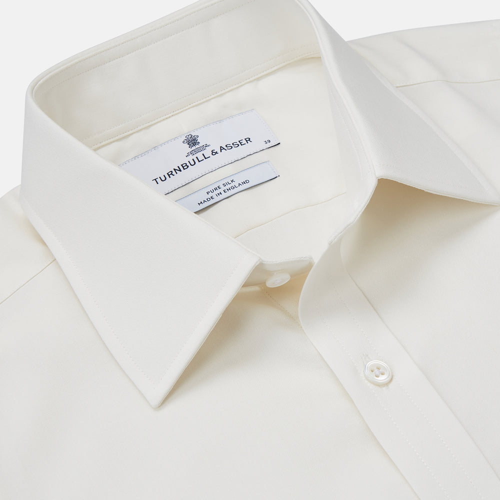 The Turnbull & Asser Cream Silk Tailored Fit Shirt is a long-sleeve button-up with a pointed collar and buttoned cuffs, displayed laid flat against a plain white background.
