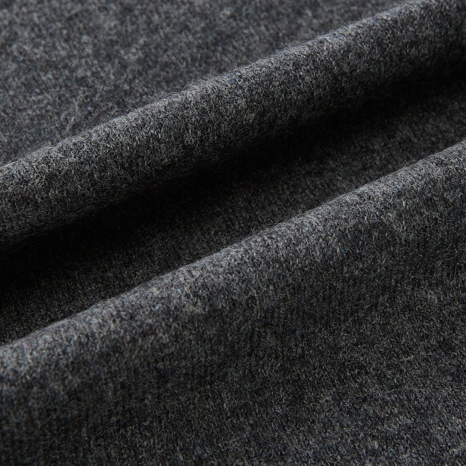 View 3 of product The Turnbull & Asser Plain Graphite Cashmere Knitted Scarf, draped and loosely knotted on a white background, showcases the refined elegance and timeless style of a luxury accessory.