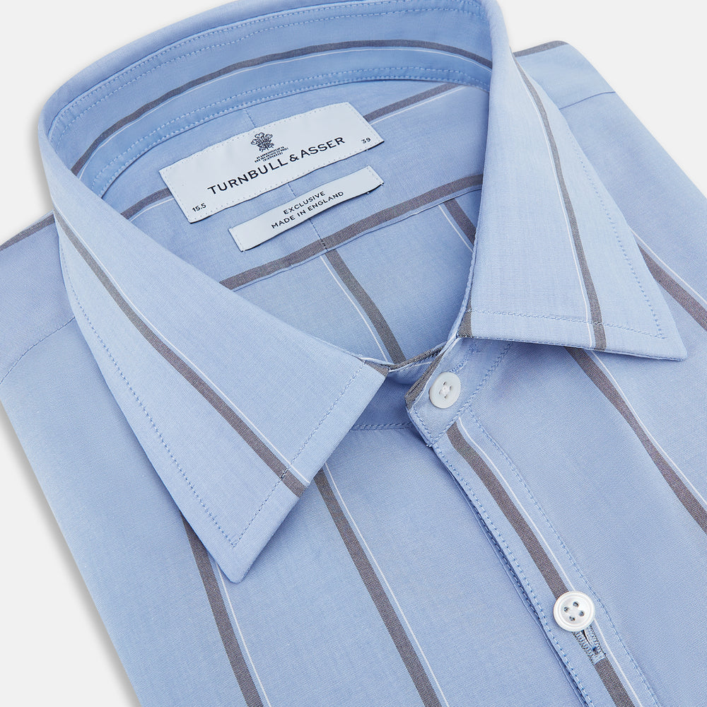 The Sky Blue Track Stripe Westminster Shirt by Turnbull & Asser features long sleeves, a Turnbull collar, and vertical dark blue and white stripes, displayed flat on a white surface.