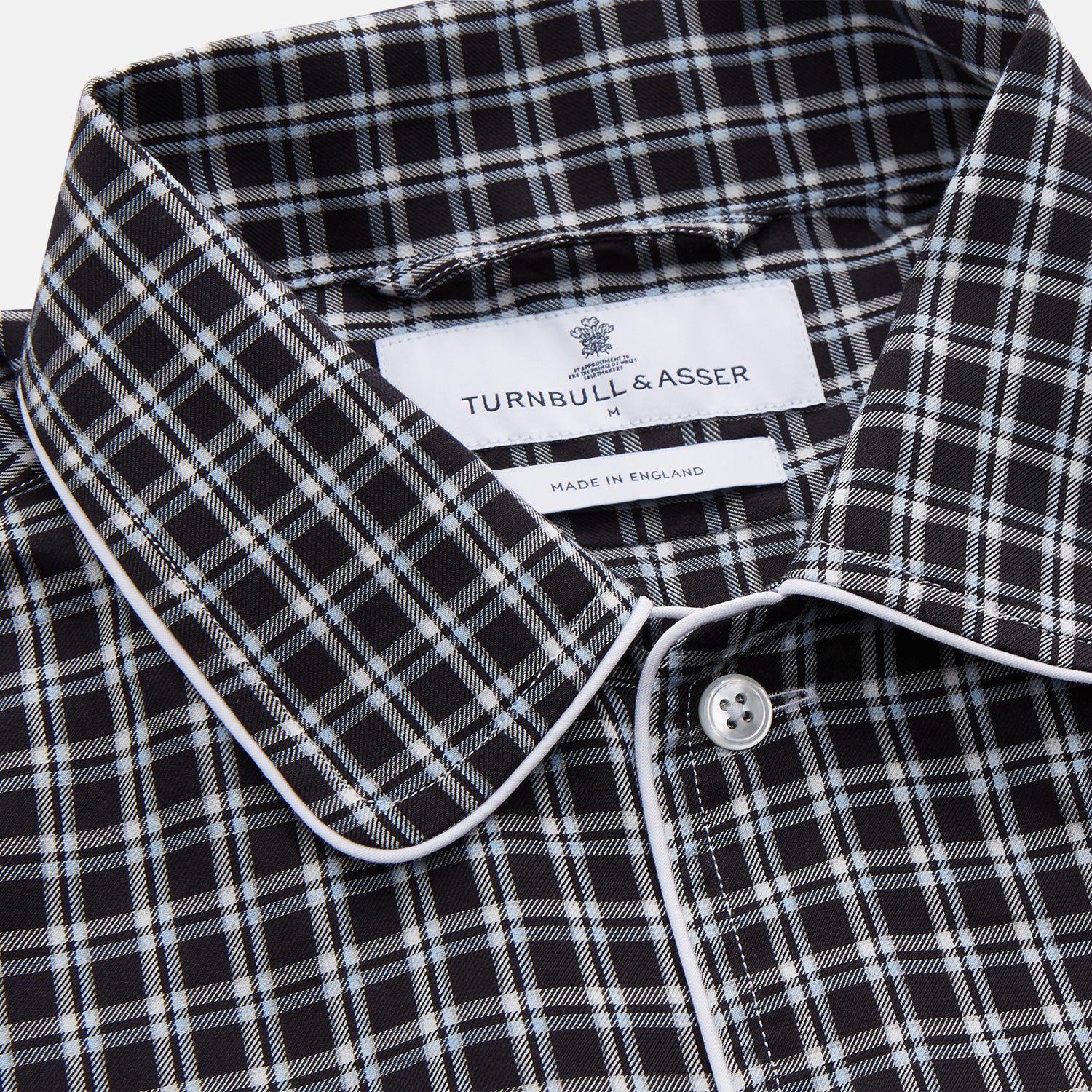 View 3 of product The Turnbull & Asser Black Multi Check Cotton Blend Sussex Nightshirt features a long sleeve, knee-length design with front buttons, a pointed collar, and chest pocket—ideal for those who love luxury sleepwear.