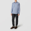 View 1 of product A person in casual attire: a Turnbull & Asser Blue Check Weekend Fit Shirt with Derby Collar and 1-Button Cuffs, dark cuffed jeans, and brown leather shoes, standing against a plain light gray background.