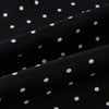 View 3 of product The Black and White Spotted Silk Scarf by Turnbull & Asser features a spotted design, neatly folded at the top and spread out at the bottom, with the brand's name printed in white near its fringed ends.