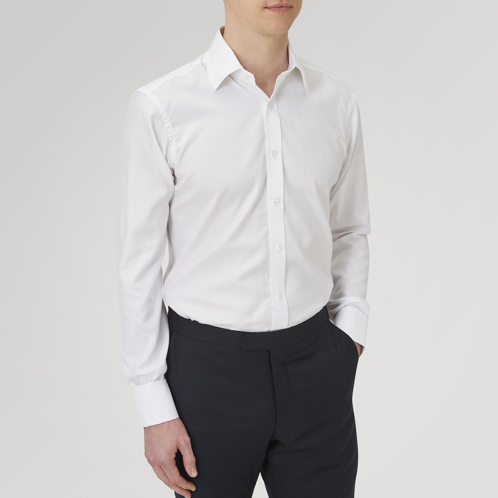 View 2 of product The Turnbull & Asser White Herringbone Sea Island Quality Cotton Shirt features a T&A collar, double cuffs, and chest pocket. Crafted for luxury with a classic design, it’s shown neatly folded against a light grey background—ideal for evening wear.