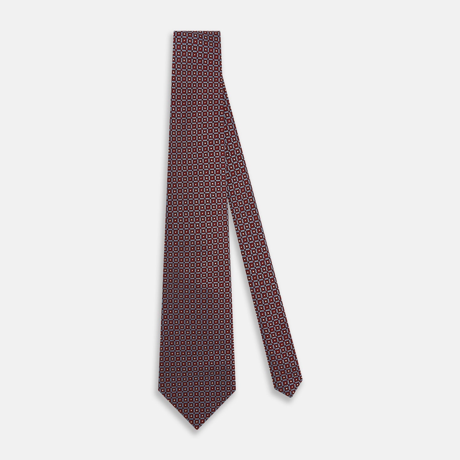 View 2 of product The Turnbull & Asser Burgundy Diamond Silk Tie features a red silk background with a repeating geometric diamond pattern of blue and white squares, exemplifying British craftsmanship.