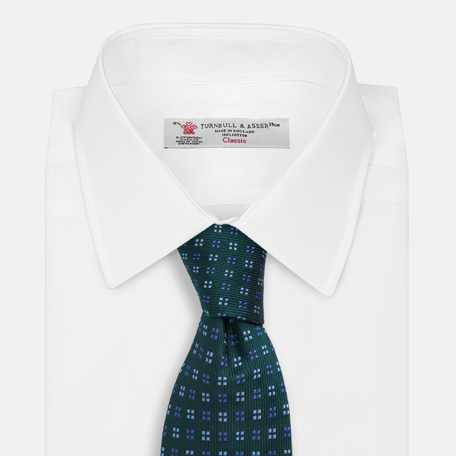 View 2 of product The MINI SQUARE SPOT FOREST GREEN BLUE TIE by Turnbull & Asser is a classic men's accessory, featuring a rolled-up green silk design with small blue geometric patterns—perfect for the modern gentleman.