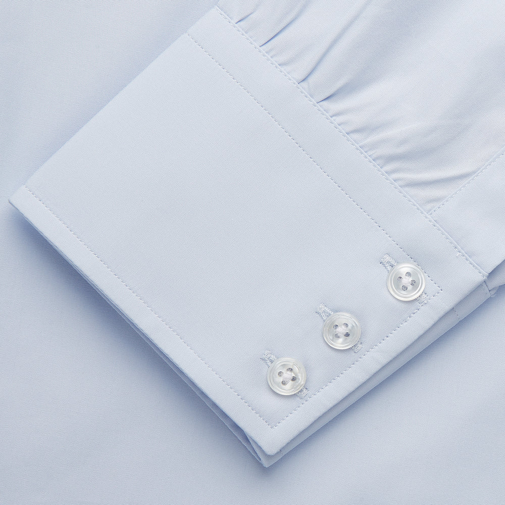 The Turnbull & Asser Tailored Fit Light Blue Cotton Shirt features a Kent collar and 3-button cuffs, perfect for pairing with a navy suit or smart ensemble. Laid flat on a white background.