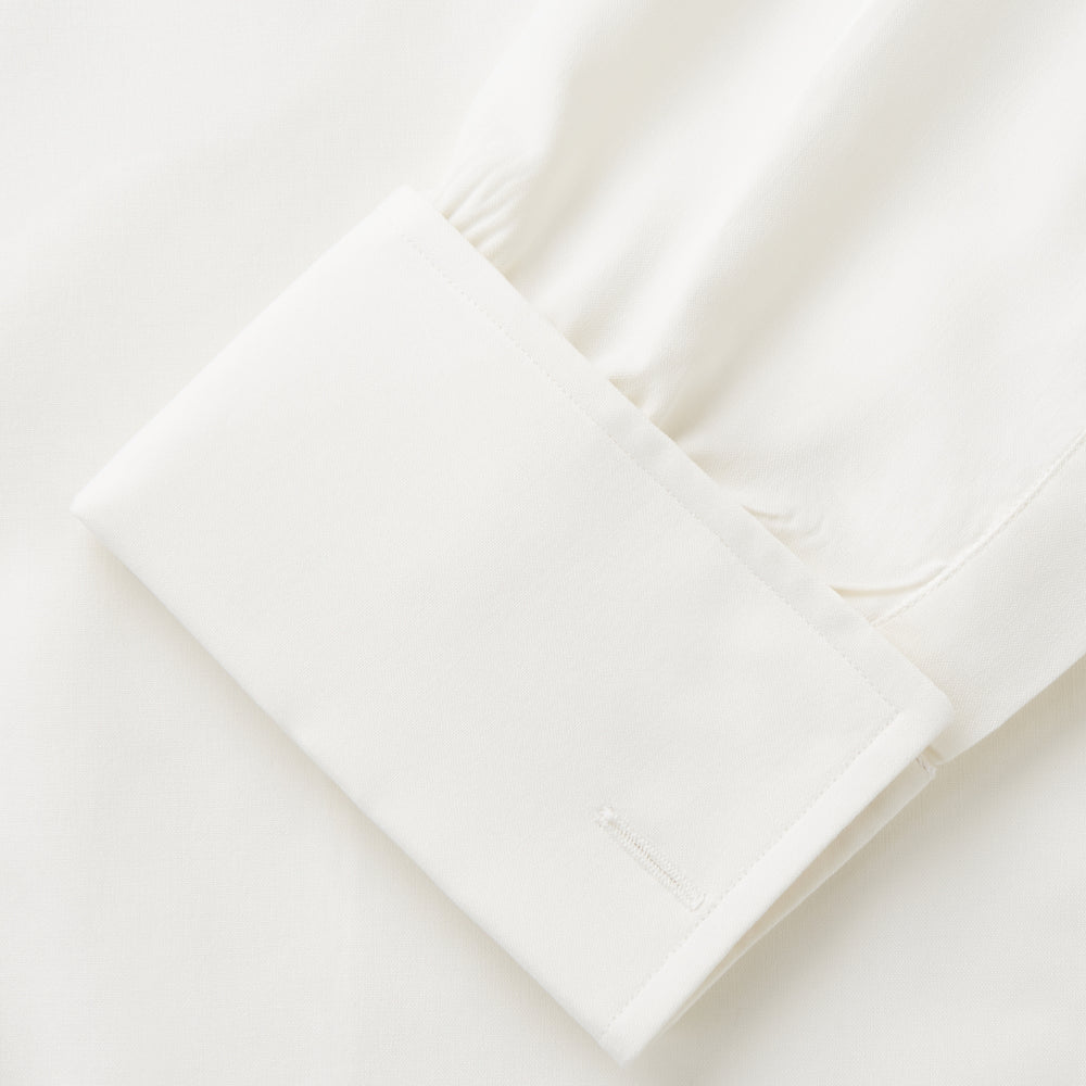 The Cream Silk Whitby Shirt by Turnbull & Asser features a pointed collar, buttoned front and cuffs, and long sleeves, shown in Whitby Fit and laid flat on a white background.