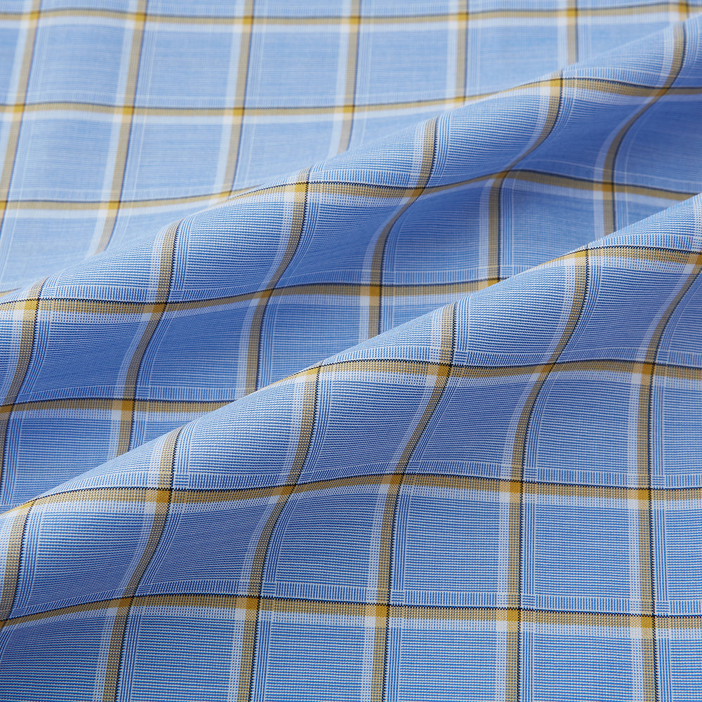 The Turnbull & Asser Blue and Yellow Windowpane Mayfair Shirt is crafted from fine Italian cotton, featuring a light blue base with yellow and white checks, shown on a plain white background.