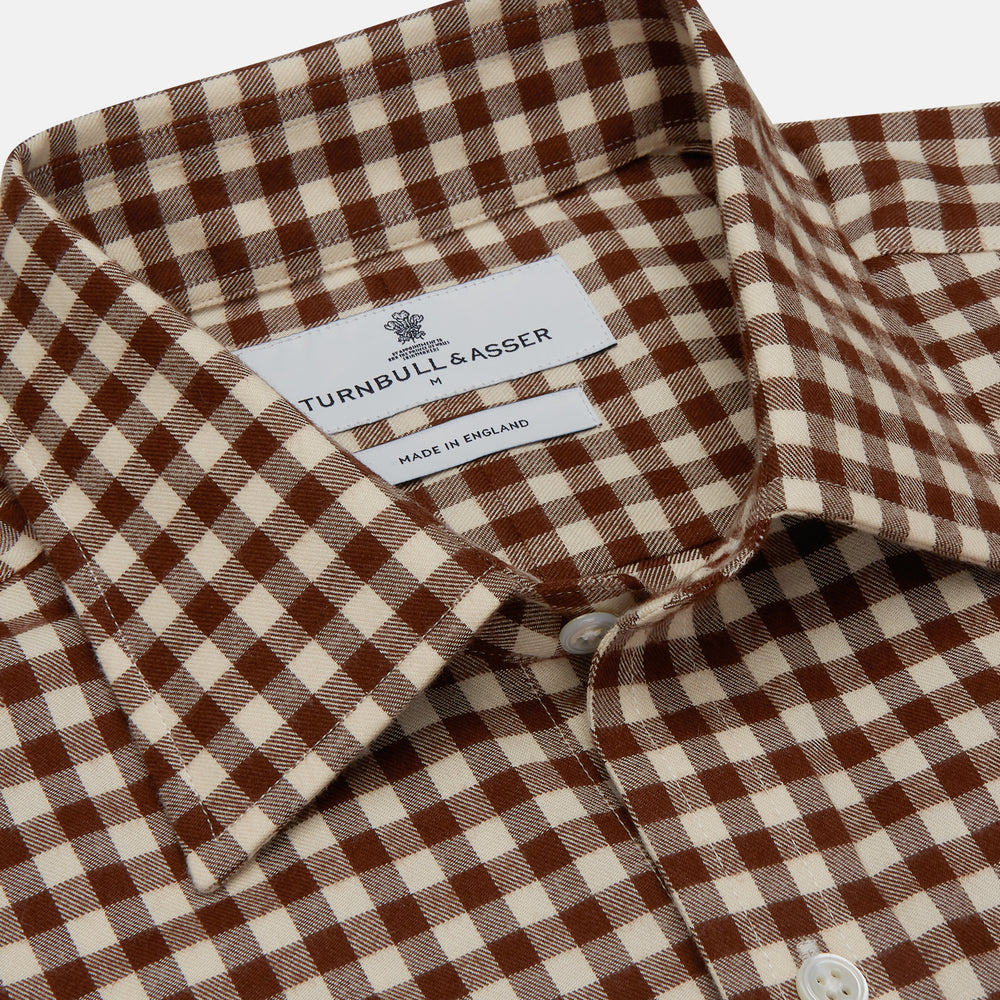 The Turnbull & Asser Brown Check Weekend Fit Shirt features a Derby collar, 1-button cuffs, and a brown check pattern—ideal for winter layering. Shown against a plain white background.