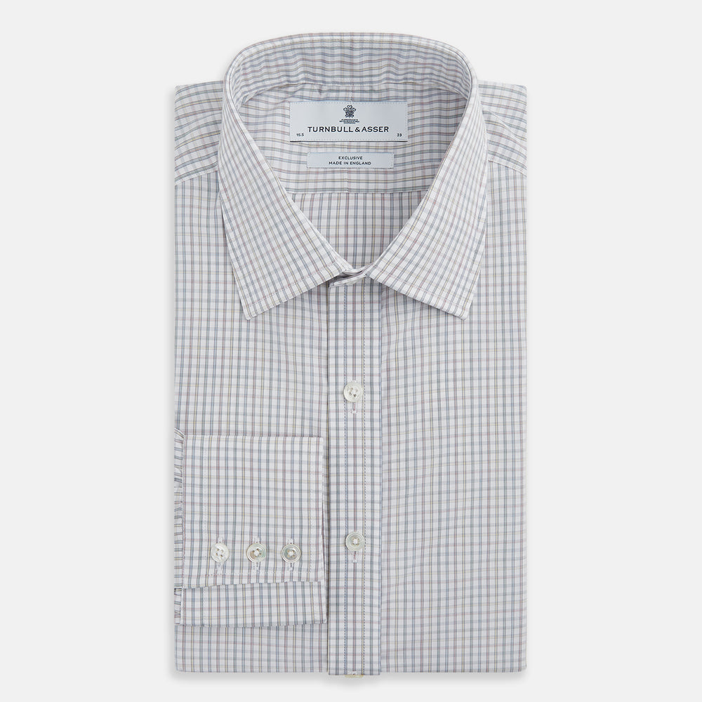 The Turnbull & Asser Sky Blue Multi Graph Check Shirt features long sleeves, a button-up front, pointed T&A collar, buttoned cuffs, and a small blue-and-white check pattern, shown on a white background.