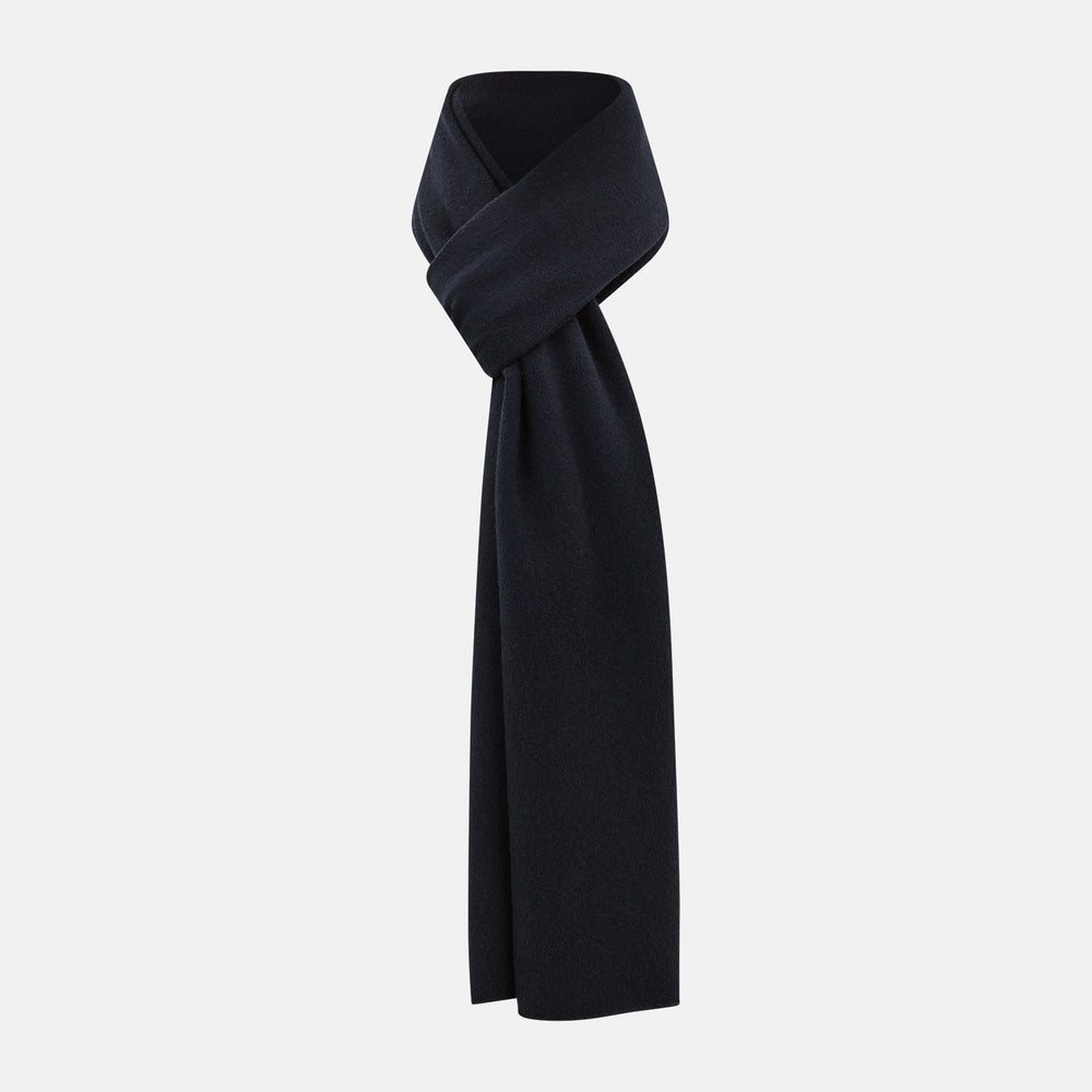 The Turnbull & Asser Plain Navy Cashmere Knitted Scarf is shown looped against a white background, highlighting its soft texture and elegant drape.