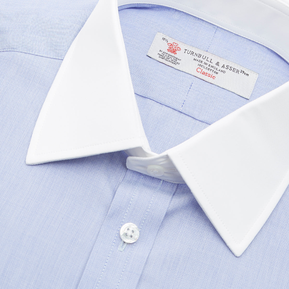 View 5 of product The Wall Street Shirt with White T&A Collar by Turnbull & Asser, as seen on Gordon Gekko, is folded neatly to showcase its light purple color, crisp French cuffs, and iconic contrasting collar against a plain background.