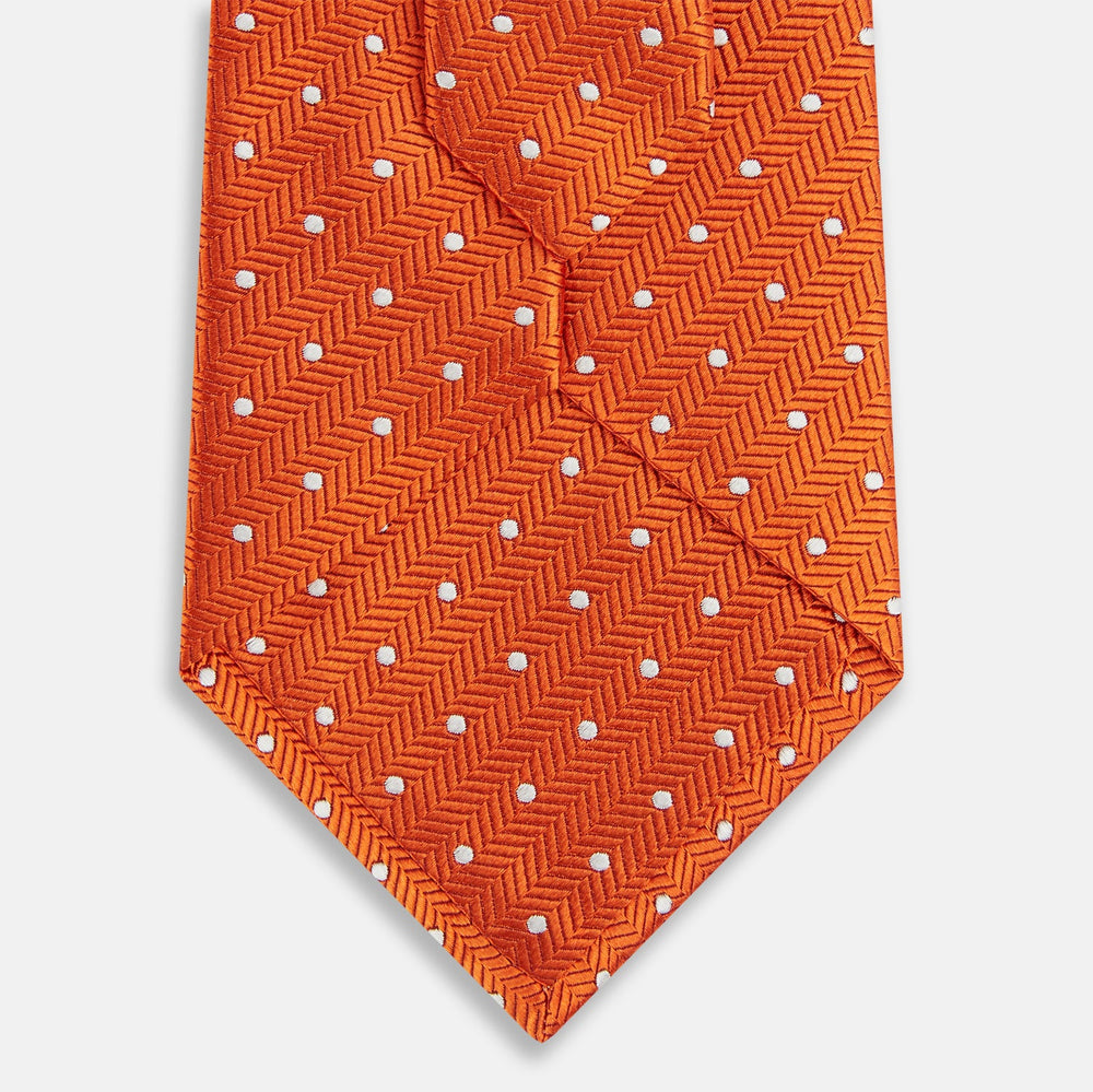 The Turnbull & Asser Orange and White Micro Dot Silk Tie features a subtle herringbone weave with small white dots—an elegant, modern accessory for the office.