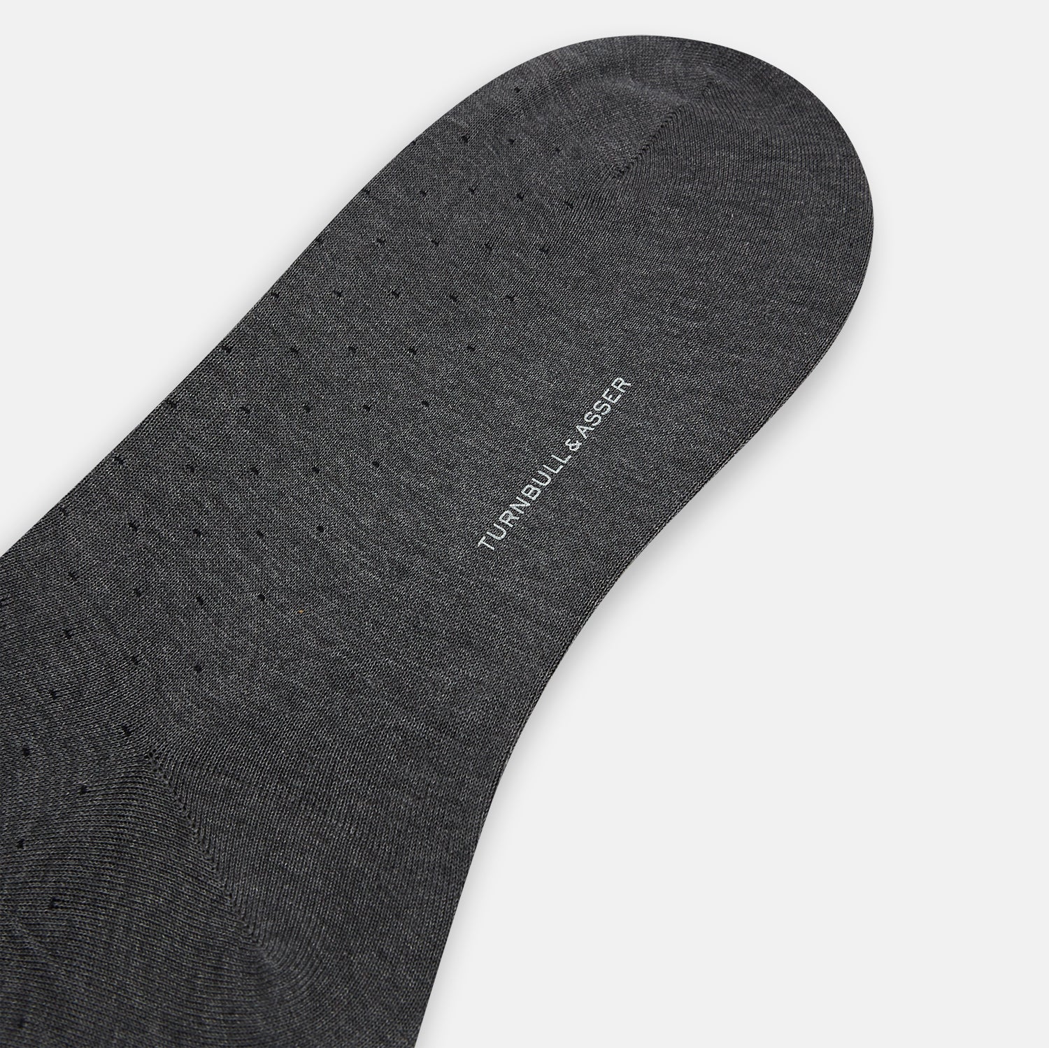 View 3 of product The image shows a single Turnbull & Asser Dark Steel/Navy Polka Dot Mid-Length Sock standing upright on a plain white background, featuring a ribbed cuff and a smooth, seamless finish.