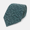 View 1 of product The Turnbull & Asser Light Petrol Paisley Silk Tie features an elegant teal and light blue paisley pattern on white English silk, highlighted by intricate, swirling designs.