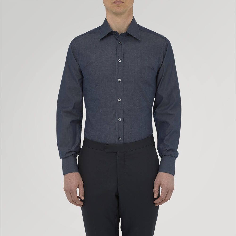A neatly folded Turnbull & Asser Dark Blue Denim-Cashmere Shirt with a T&A collar and double cuffs, featuring black buttons, shown on a white background. The label inside the collar highlights its smart finish and refined style.