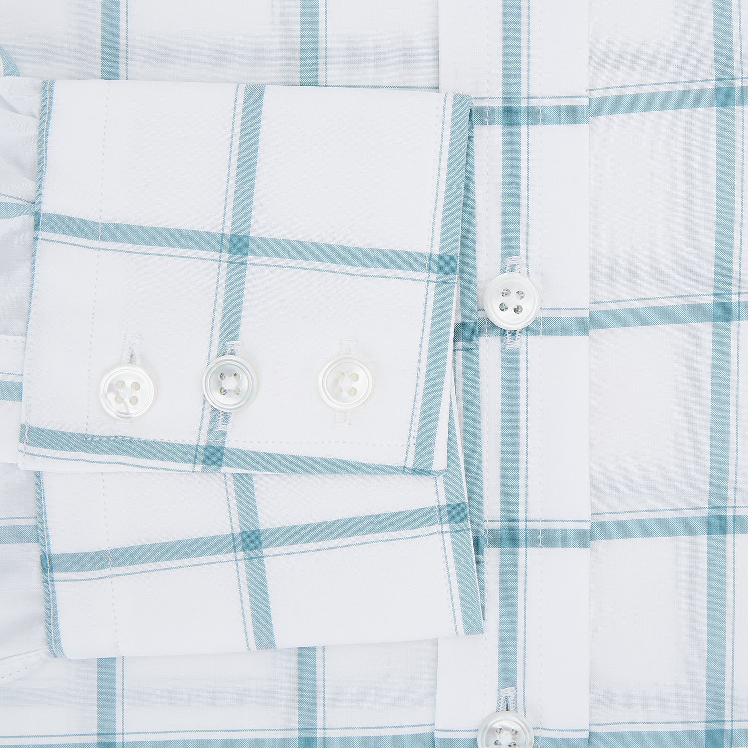 View 4 of product The Turnbull & Asser Sage Grid Check Mayfair Shirt is a white, long-sleeve shirt made from Italian cotton with a light blue and sage grid pattern, shown neatly laid flat on a plain, light background.
