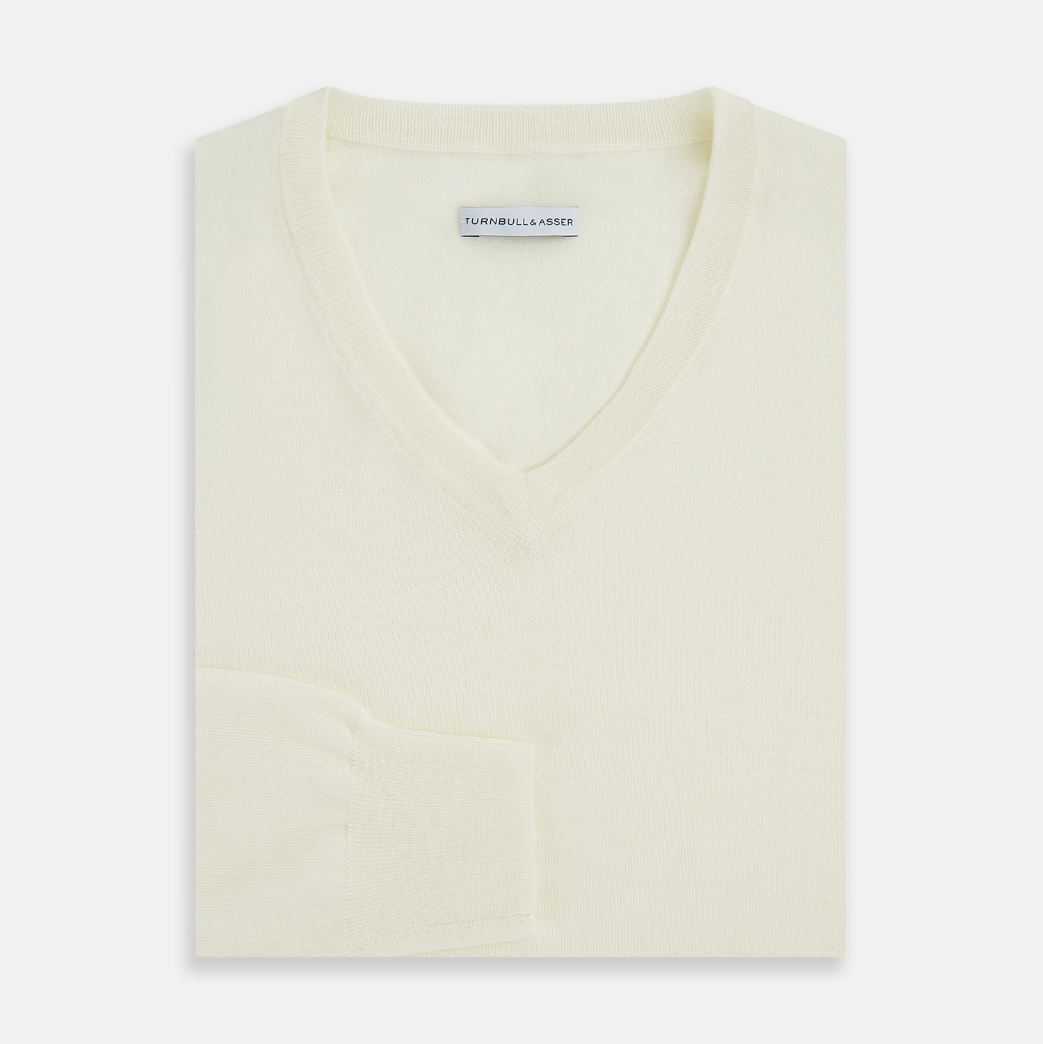 View 4 of product The Turnbull & Asser Cream Fine Merino V-Neck Jumper features long sleeves and classic styling, displayed against a white background.