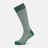 View 1 of product The Turnbull & Asser Ivory Houndstooth Mid-Length Sock features a green and white houndstooth pattern with solid green cuff, heel, and toe accents. Displayed on a plain white background.