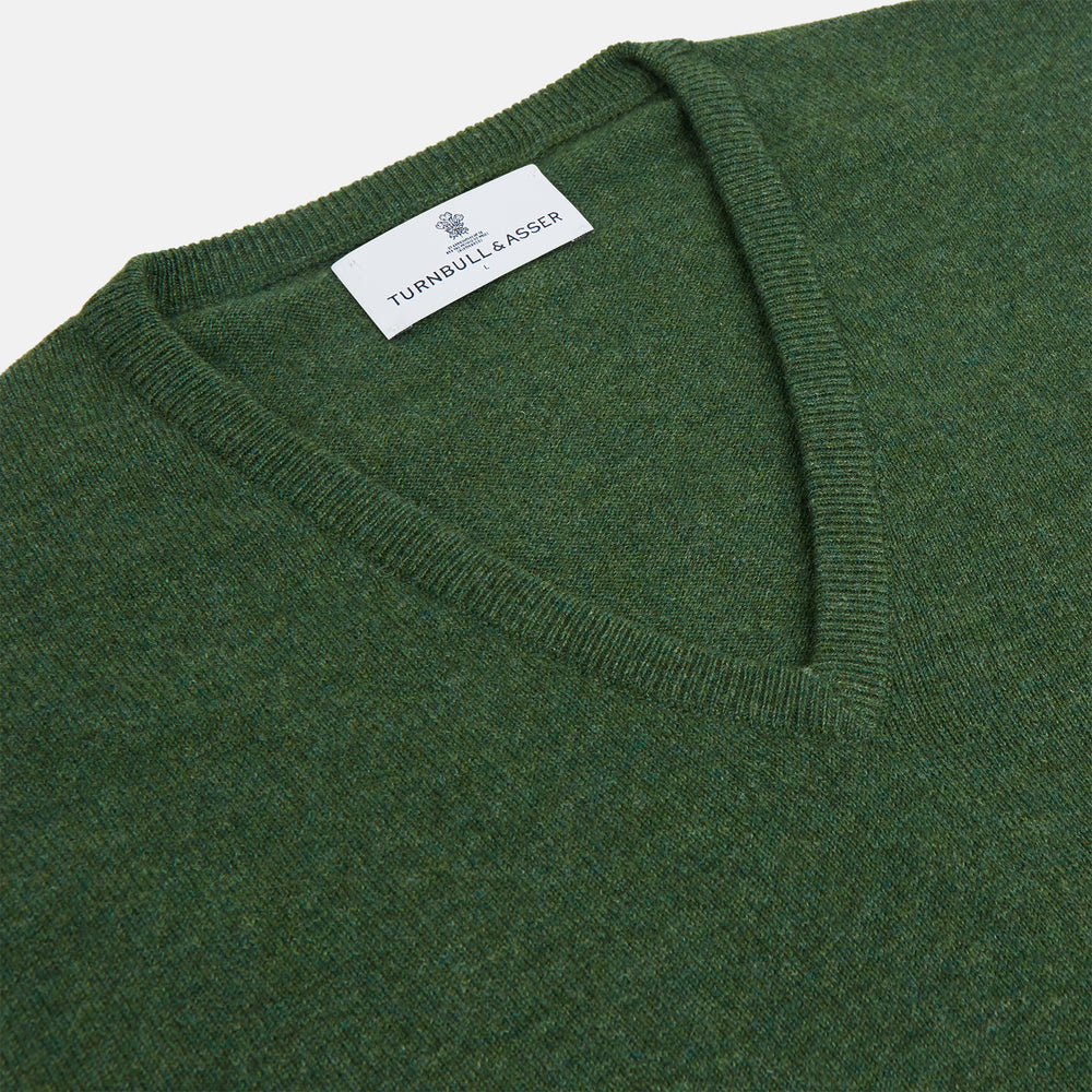 The Turnbull & Asser Green V-Neck Cashmere Jumper, made from soft Scottish cashmere, features long sleeves with ribbed cuffs and a ribbed hem. It is shown laid flat on a white background.