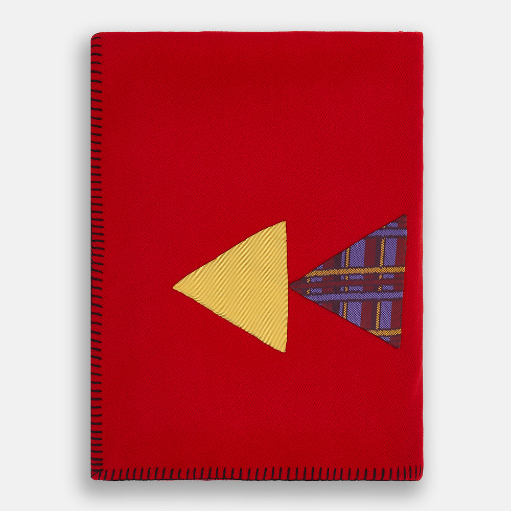 The Turnbull & Asser Red Applique Hand Stitched Lambswool Blanket features black-stitched edges and handsewn tie silk patches, including a yellow triangle and plaid triangle arranged to form a stylized fish.