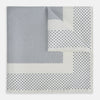 View 1 of product The Turnbull & Asser Cream Dot Silk Pocket Square features a neatly folded pure silk design with a border and center pattern of small navy blue polka dots, displayed on a plain white background.
