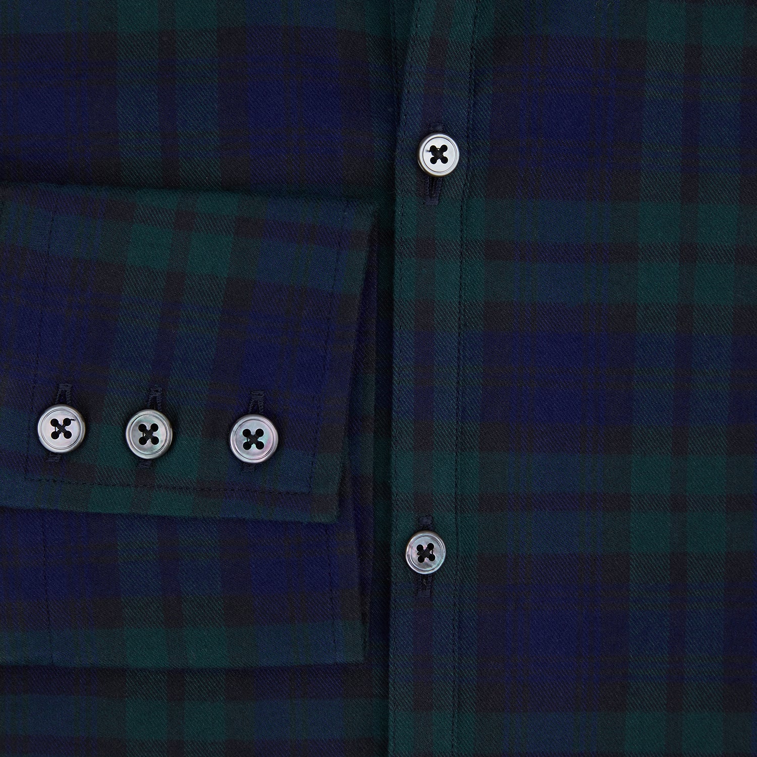 View 4 of product The Turnbull & Asser Black Watch Tartan Windsor Shirt is a long-sleeve, button-up shirt with a dark green and navy tartan pattern, white buttons, collar, and curved hem—showcasing British craftsmanship on a plain white background.