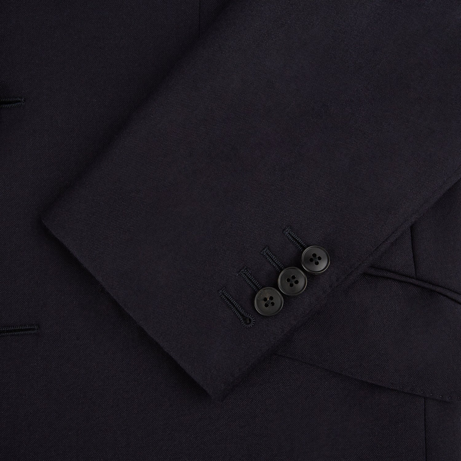 View 7 of product The Turnbull & Asser Short Navy Single Breasted Suit is shown flat on a white background, with a notch lapel jacket featuring two front pockets and matching trousers neatly folded underneath.