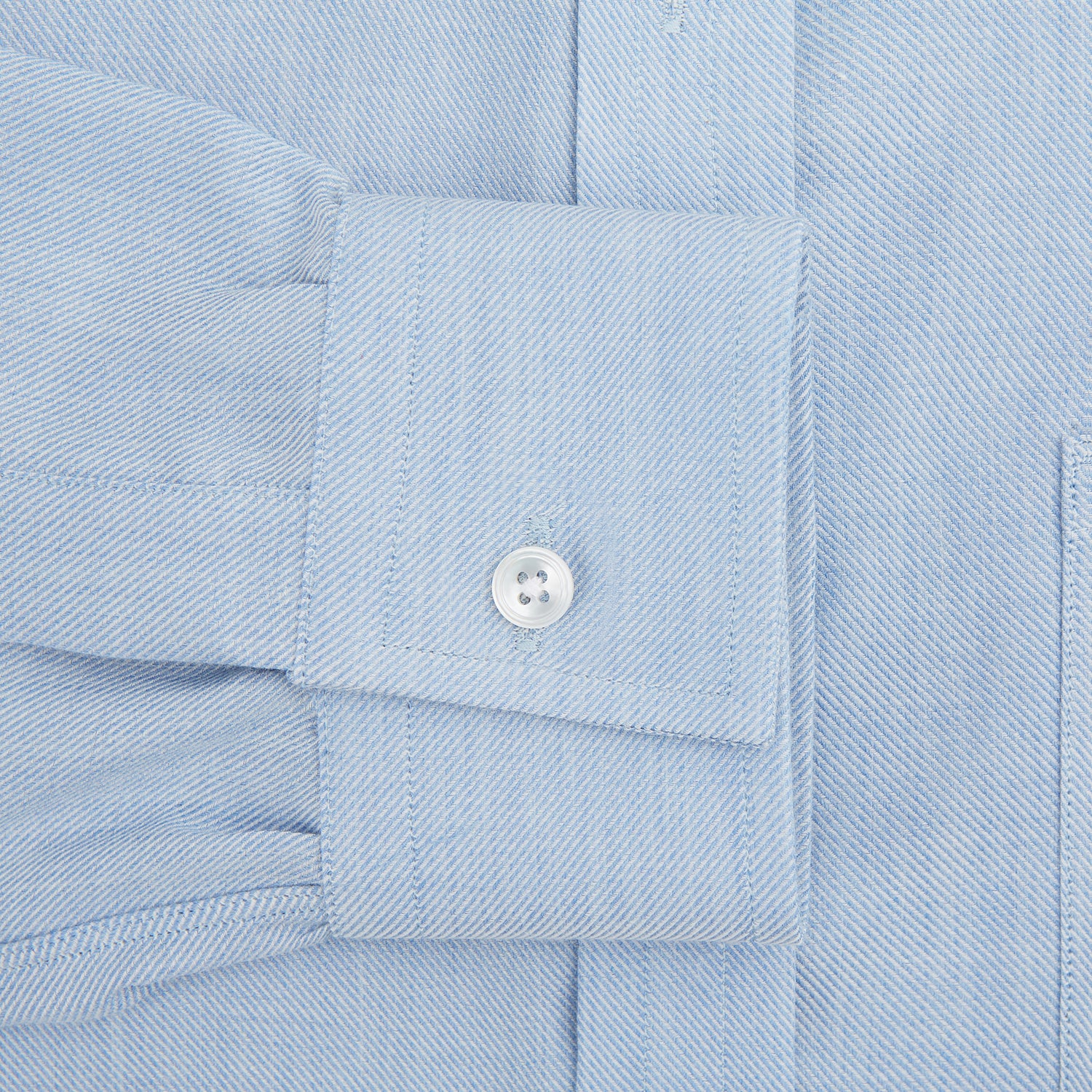 View 3 of product The Turnbull & Asser Pale Blue Cotton Cashmere Derby Collar Richmond Shirt features a soft cotton-cashmere blend, derby collar, white buttons, left chest pocket, and buttoned cuffs, shown laid flat on a white background.
