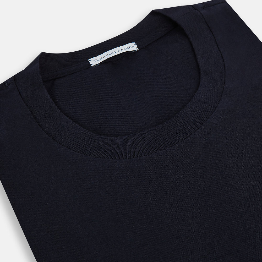 A navy short-sleeve pyjama shirt by Turnbull & Asser is laid flat on a white background, displaying the front view. Its soft fabric ensures comfort with no visible logos, designs, or patterns on the shirt.