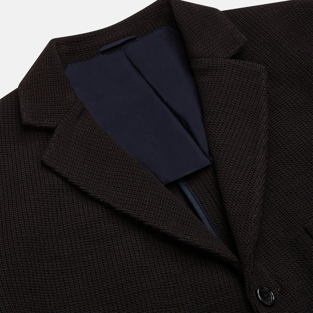 The Turnbull & Asser Dark Chocolate Knitted Cambridge Blazer for men, made from fine Italian wool with British tailoring, features a notched lapel, three front buttons, and three patch pockets, shown on a plain white background.