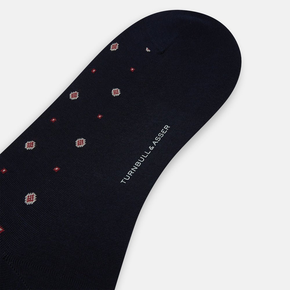 The Turnbull & Asser Midnight Patterned Mid-Length Sock features a ribbed cuff and a design of small white hexagons with red dots, shown here as a single sock on a plain white background.