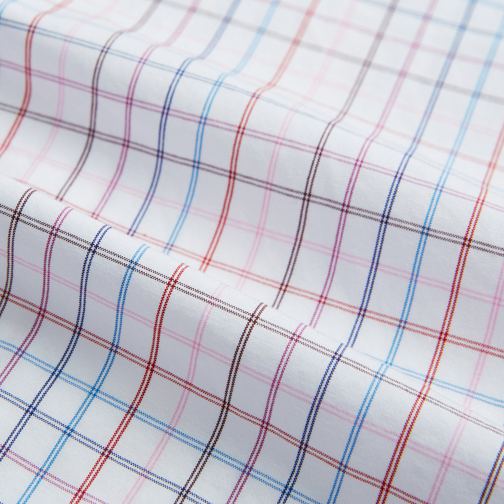 The Turnbull & Asser Pink Multi Double Grid Check Mayfair Shirt, made from organic cotton with a pointed collar and buttoned cuffs, features a light pink base with blue and red grid checks and is shown flat on a white background.
