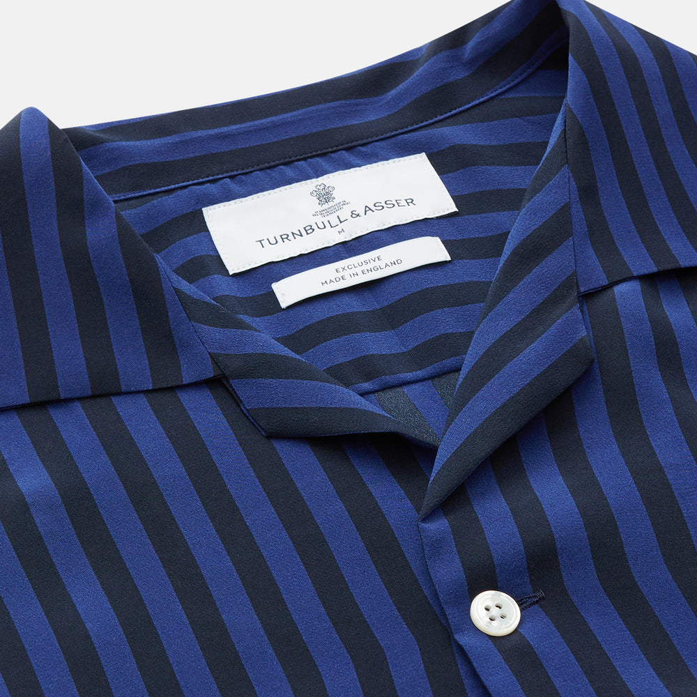 The Turnbull & Asser Navy and Blue Multi Stripe Silk Holiday Fit Winnington Shirt features white buttons, a notched collar, and a chest pocket, shown laid flat on a white background.