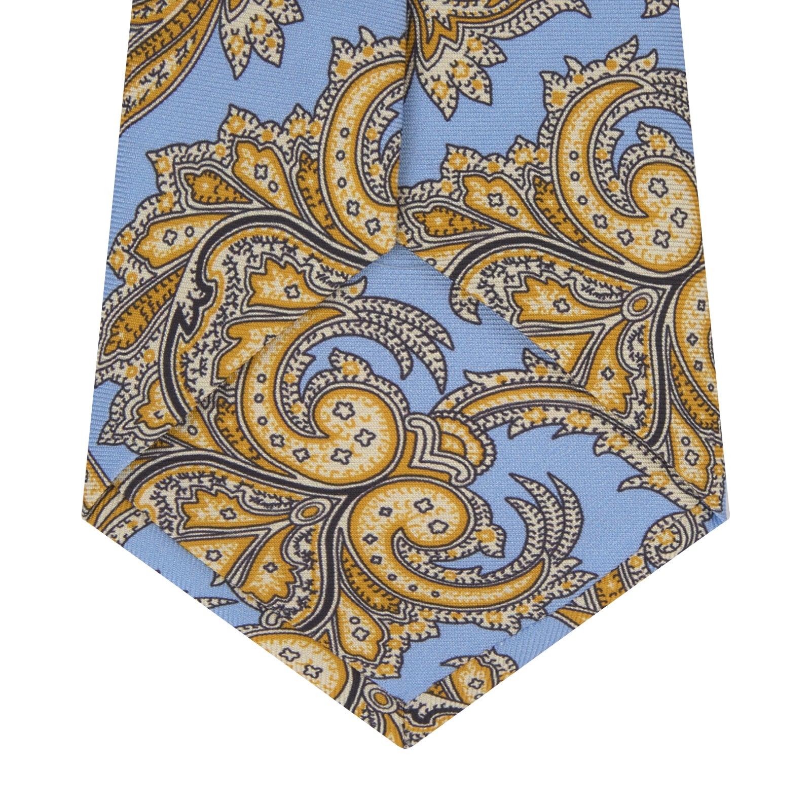 View 4 of product The Turnbull & Asser GGT92000 3062 06 OS is a rolled-up necktie with an intricate blue and yellow paisley pattern on a light blue background—a stylish accessory for any wardrobe.