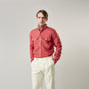 View 8 of product The Turnbull & Asser Plain Red Linen Weekend Fit Shirt with Stand Collar features long sleeves, a button-up front, and two buttoned-flap chest pockets. It is shown neatly laid flat on a plain light background.