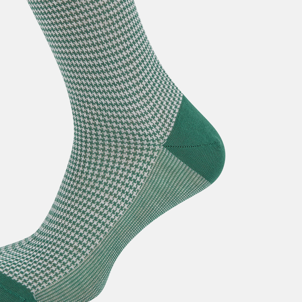 The Turnbull & Asser Ivory Houndstooth Mid-Length Sock features a green and white houndstooth pattern with solid green cuff, heel, and toe accents. Displayed on a plain white background.