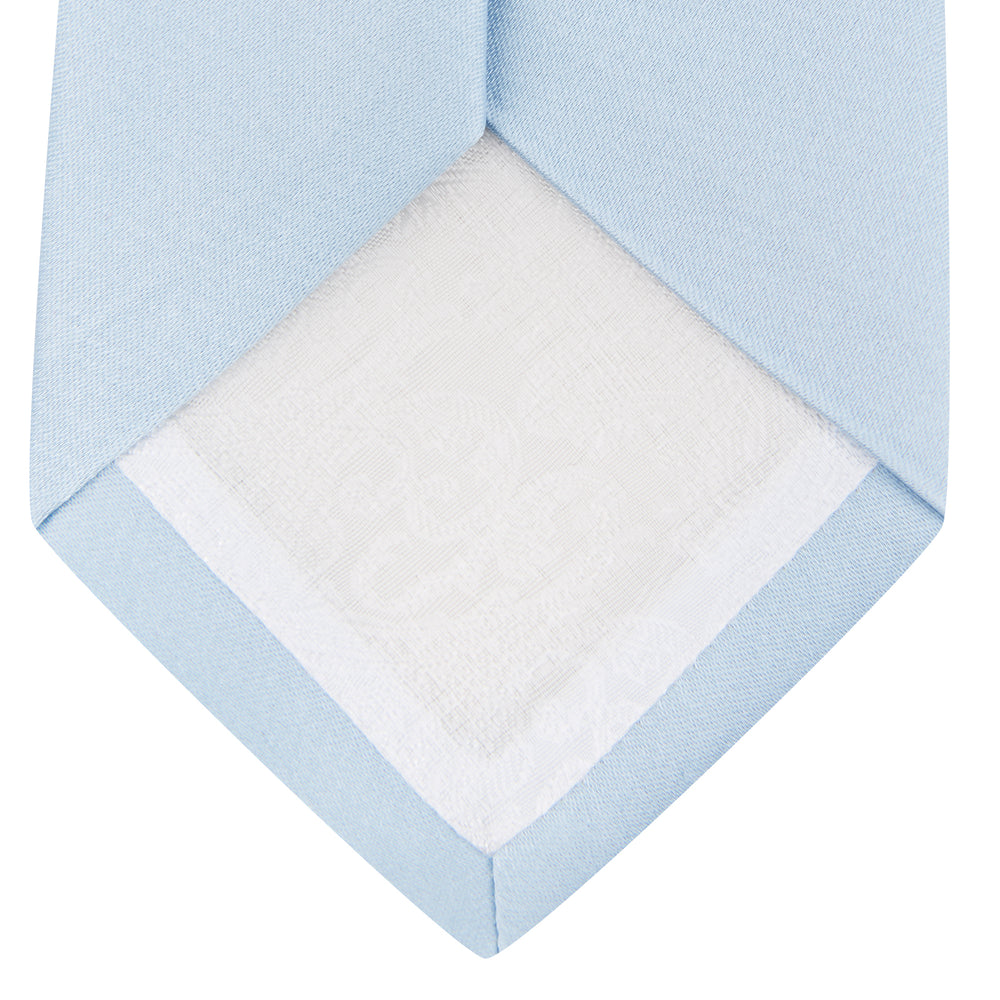 The Turnbull & Asser Plain Woven Satin Silk Tie, in light blue, is neatly rolled and displayed on a plain white background—an essential accessory for refined style.