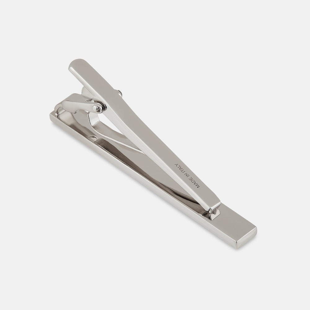 The Turnbull & Asser Burgundy Patterned Tie Bar features a rectangular sterling silver design with a burgundy inlay, ideal for formal attire, shown on a plain white background.