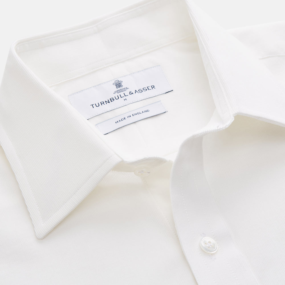 The White Cotton Weekend Fit Langston Shirt by Turnbull & Asser, with a Derby collar, long sleeves, and two button-flap chest pockets, is shown laid flat on a white background.