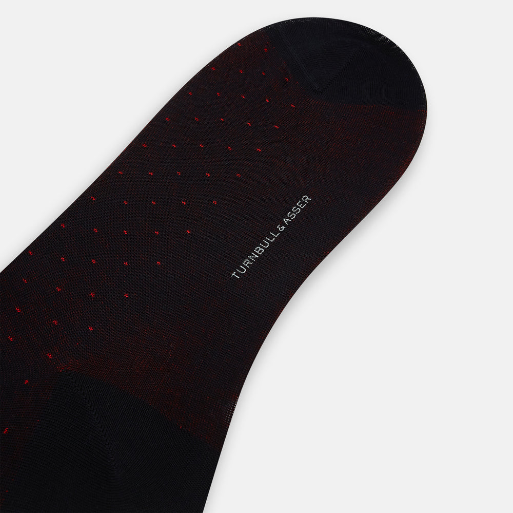 The Turnbull & Asser Navy/Red Polka Dot Mid-Length Sock is shown against a white background, featuring small red dots and solid black cuff, heel, and toe for classic style.