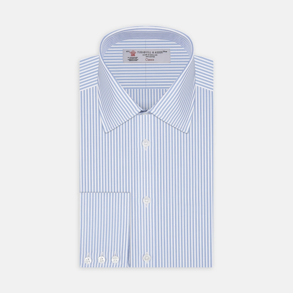 A close-up of Turnbull & Asser’s Light Blue Bengal Stripe Cotton Fabric shows its light blue and white vertical stripes pattern inside a gray circular frame on a white background.