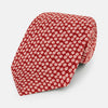 View 1 of product The Turnbull & Asser Red Flower-Patterned Printed Silk Tie, made from fine English silk, features a repeating white floral design and is shown rolled on a plain white background.