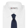 View 2 of product The Turnbull & Asser Navy Plain Woven Grenadine Silk Tie, an essential accessory, is rolled at one end and displayed on a plain white background.
