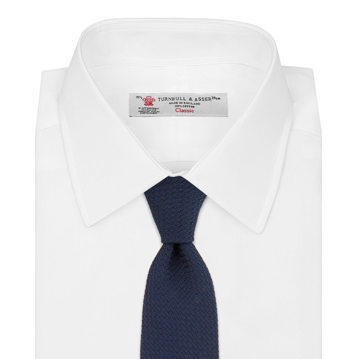 View 2 of product The Turnbull & Asser Navy Plain Woven Grenadine Silk Tie, an essential accessory, is rolled at one end and displayed on a plain white background.