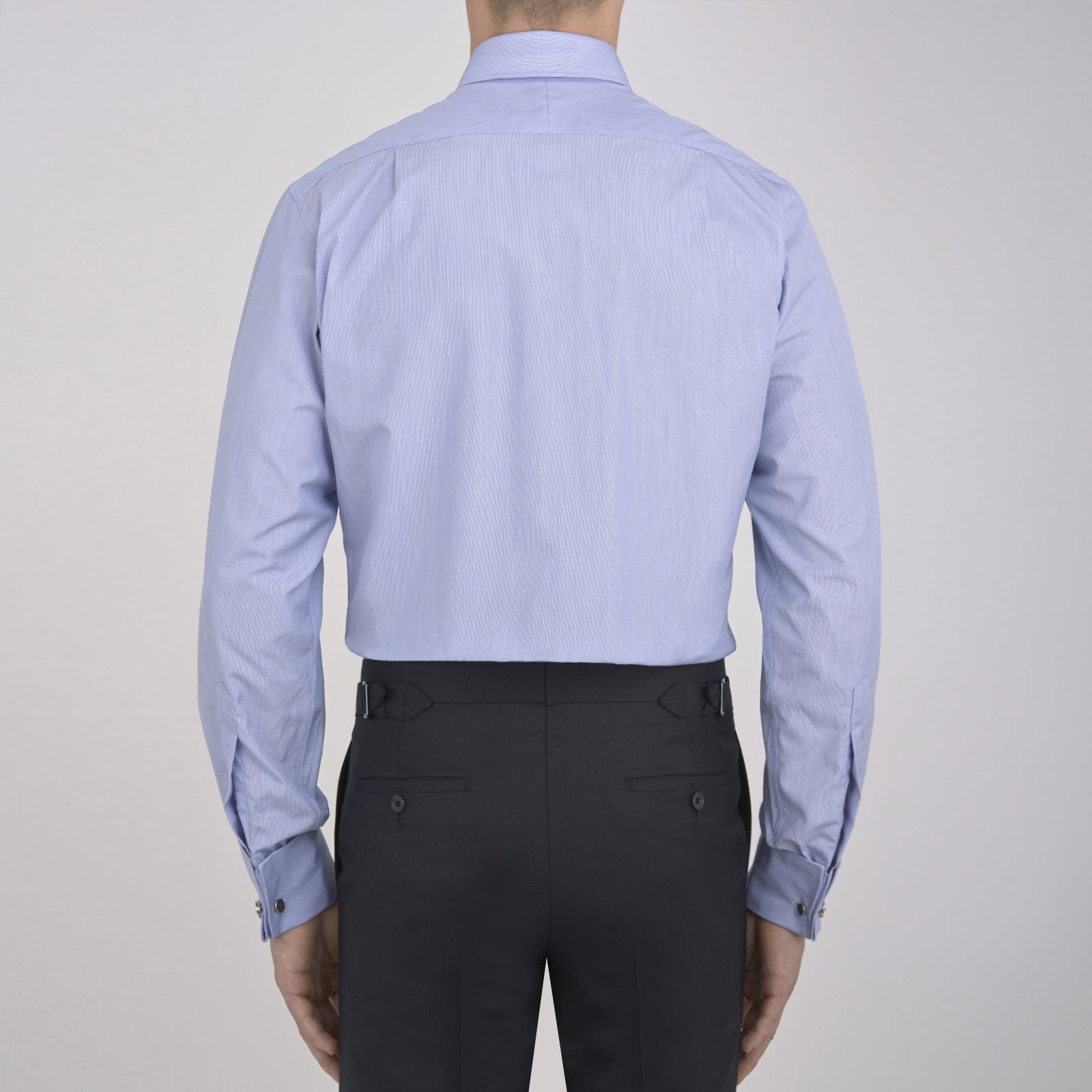 View 3 of product The Turnbull & Asser Blue Hairline Stripe Shirt features a T&A collar, 3-button cuffs, and white buttons. Made from light blue cotton with subtle stripes, it’s neatly folded with the label visible inside the collar on a plain white background.