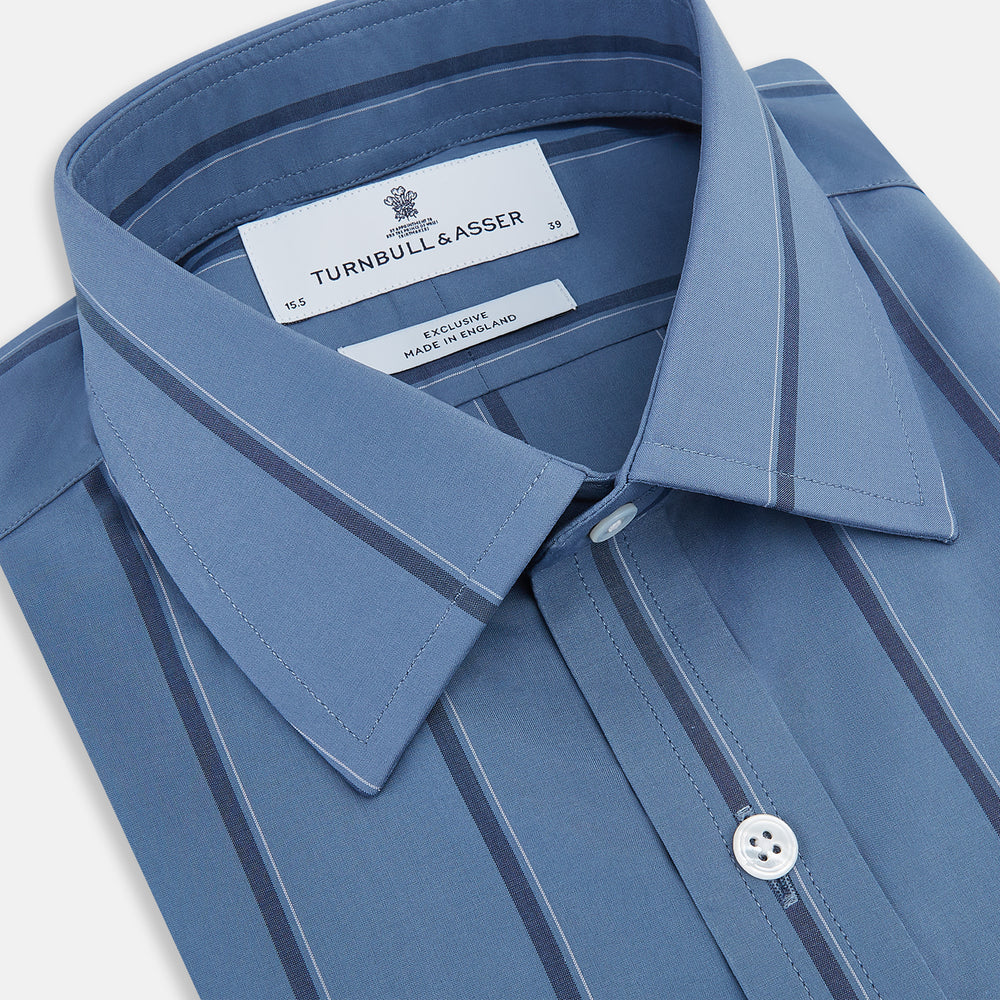 The Turnbull & Asser Steel Grey and Navy Track Stripe Mayfair Shirt features long sleeves, a collar, white buttons, and a relaxed fit, shown on a plain white background.
