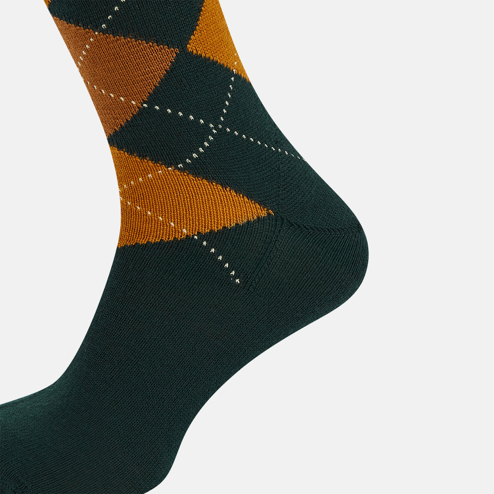 The Forest Green Wool Check Mid-Length Socks by Turnbull & Asser feature a dark green base with orange and brown argyle checks and white dotted lines, shown against a plain white background.