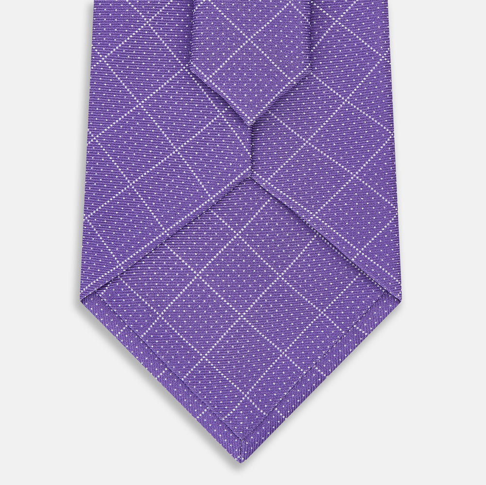 The Turnbull & Asser Purple Dotted Check Pattern Printed Silk Tie is displayed rolled up on a white background, featuring a subtle check design for an elegant look.